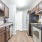 Spacious and well lit kitchen with wood flooring and stainless steel appliances