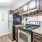Spacious and well lit kitchen with wood flooring and stainless steel appliances