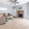 Spacious and well lit living room with wood flooring, large windows and open access to the kitchen